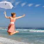 happy person jumping for joy on beach summer vacation