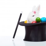 Cute white rabbit with colorful easter eggs in magician hat